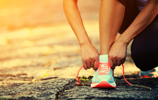 young woman runner tying shoelaces